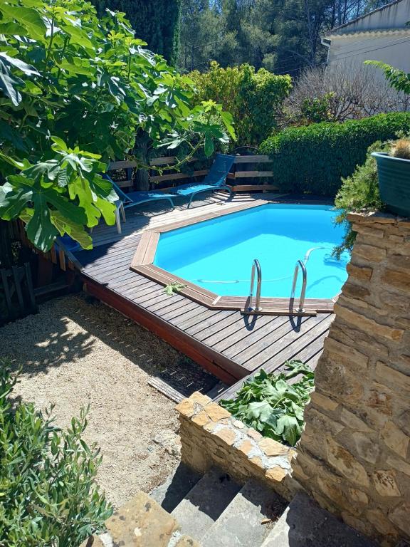 een zwembad op een houten terras naast het afficiency bij VILLA AVEC PISCINE A 400M DE LA PLAGE in Sanary-sur-Mer