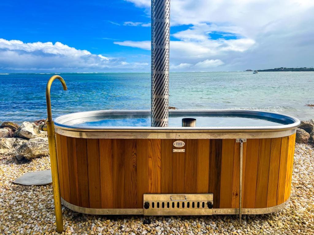 a jacuzzi tub on the beach next to the ocean at The Sandcastle House at Pelican Point in Carpenter Rocks
