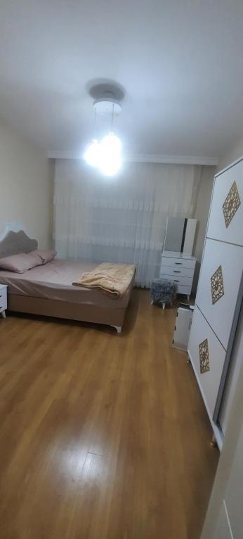 a bedroom with a bed in a room with wooden floors at مجمع انوفيا2 in Esenyurt