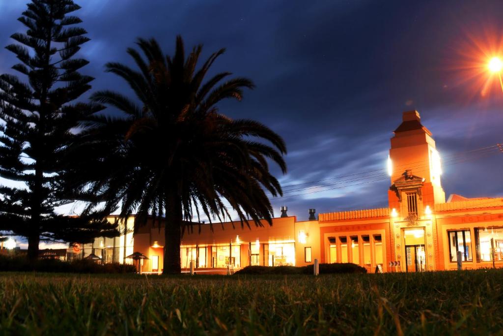 un edificio con una palmera delante de él en The Central Hotel Motel Lakes Entrance, en Lakes Entrance