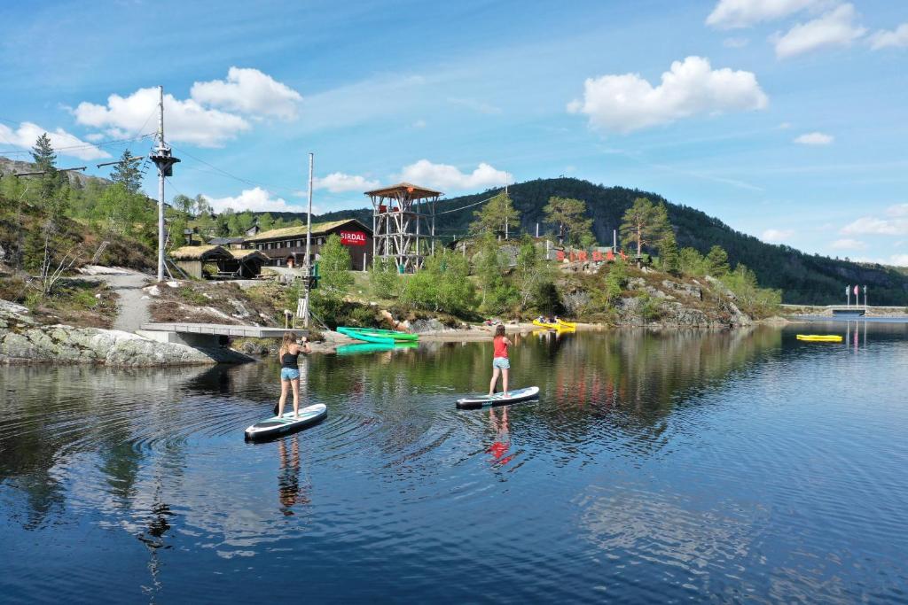 Tjørhom的住宿－Sirdal fjellpark，两个人站在水中的桨板上