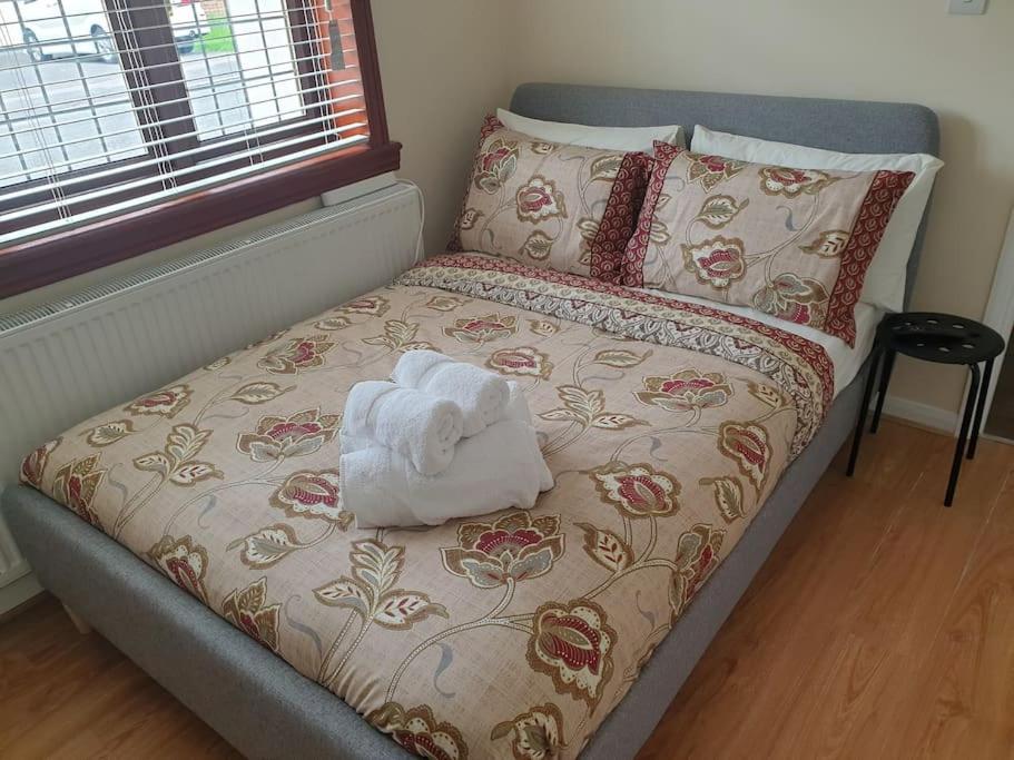 a bed with a towel on top of it at London Luxury 6 Bedroom Family House Sleeps 12 people Parking for 4 Cars Close to tube. in Chigwell