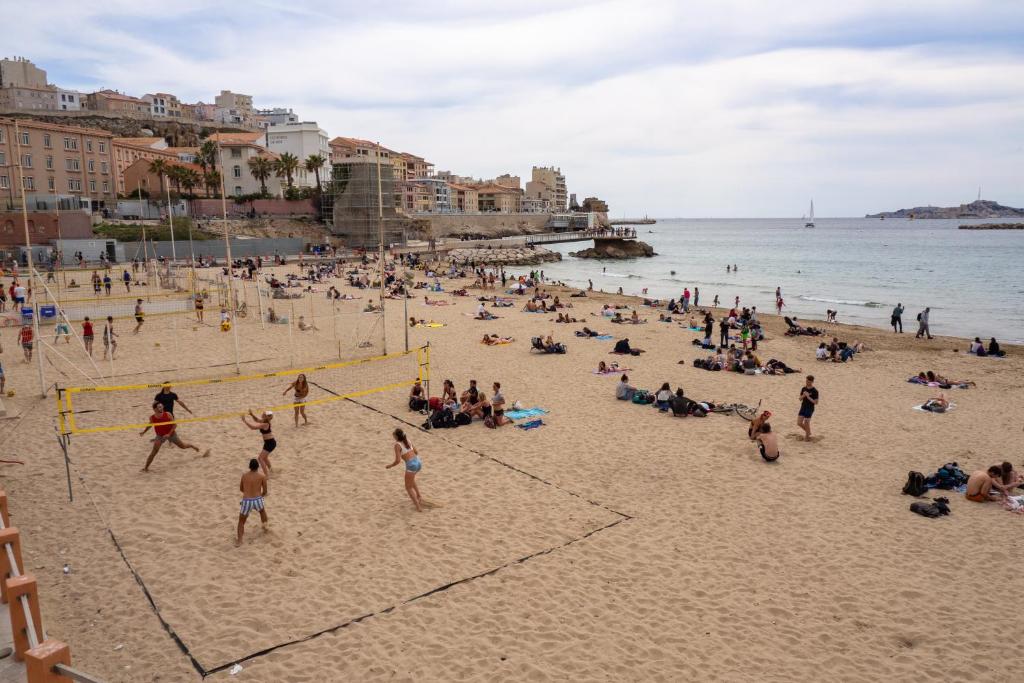 grupa ludzi grających w siatkówkę na plaży w obiekcie Appartement Architecte Catalans- Bord de mer w Marsylii
