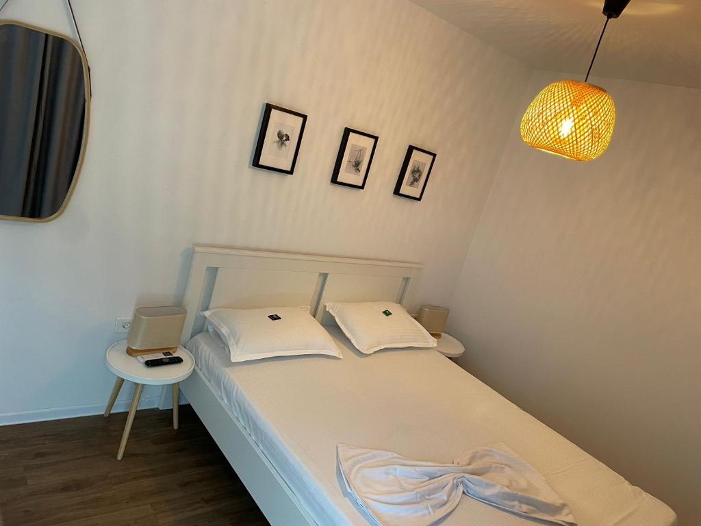 a bedroom with a bed and a table and a lamp at Daro tiny house in Vama Veche