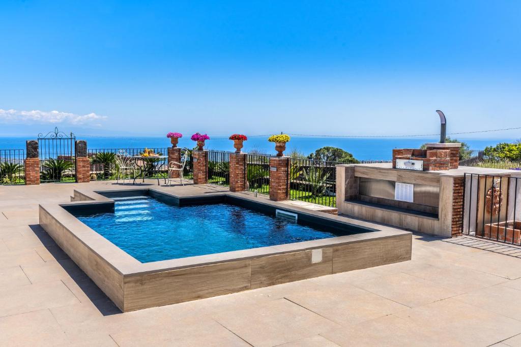 una piscina con vista sull'oceano sullo sfondo di CASA ZU' SARU a Giarre