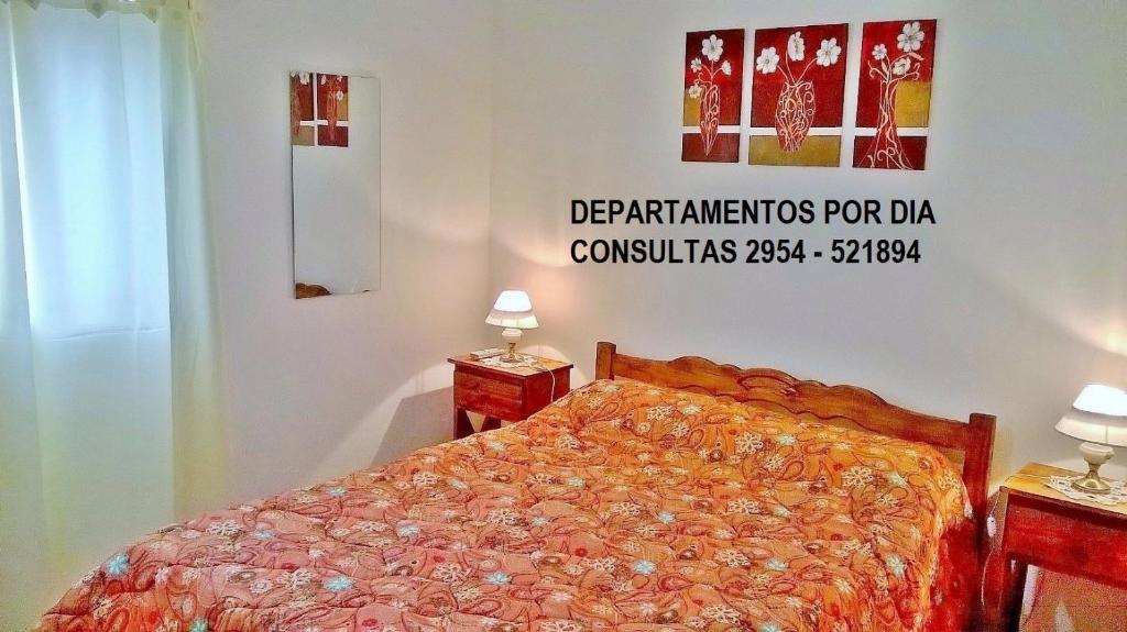 a bedroom with a bed with a sign on the wall at Departamentos San Jorge in Santa Rosa