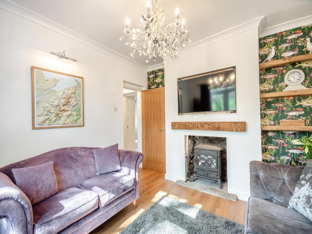 a living room with a couch and a fireplace at Glanllyn in Betws-y-coed