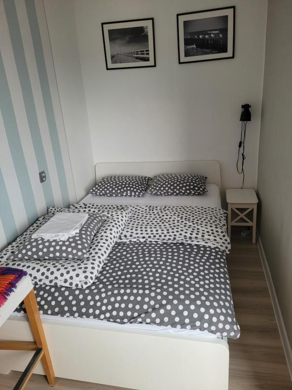 łóżko z czarno-białą pościelą w sypialni w obiekcie Kawalerka Gdynia w mieście Gdynia