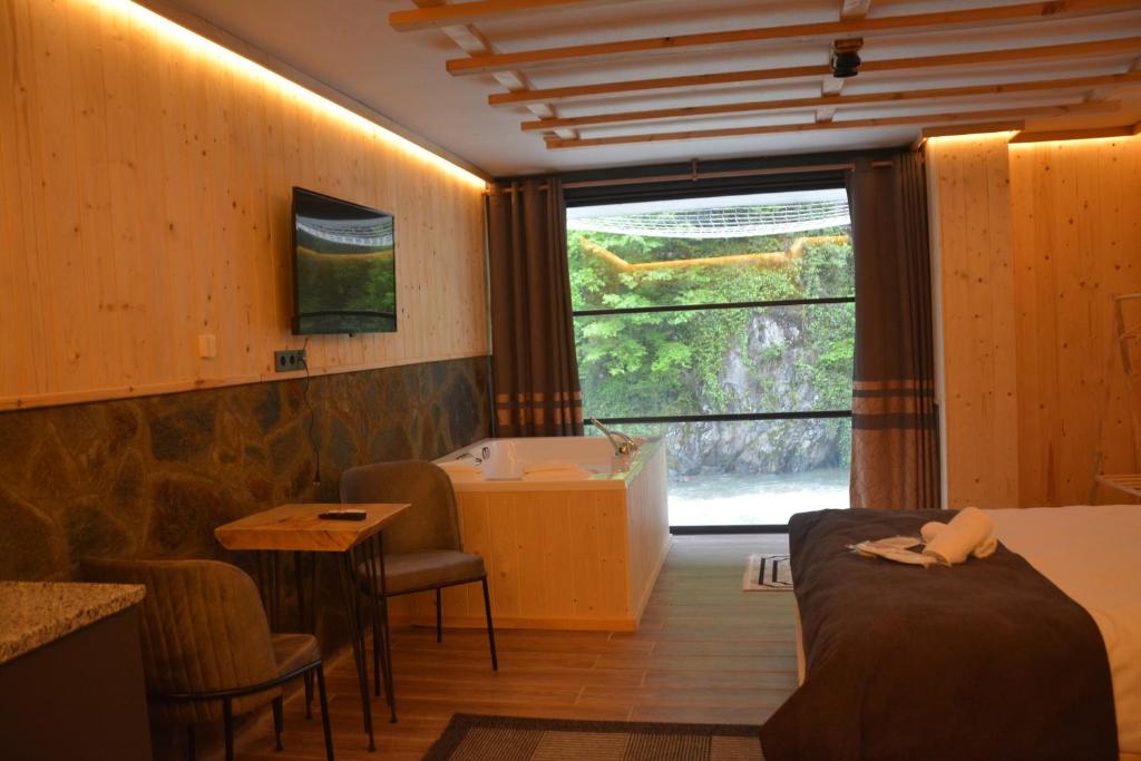 a room with a bed and a bathroom with a tub at DOĞAL SUİT BUNGALOV in Ardeşen