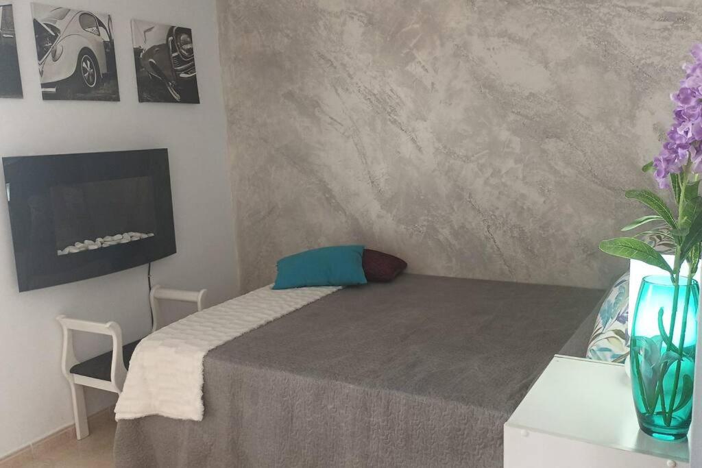 a bedroom with a bed with a table and a tv at ApartPlaya (1ª Línea) in Melilla
