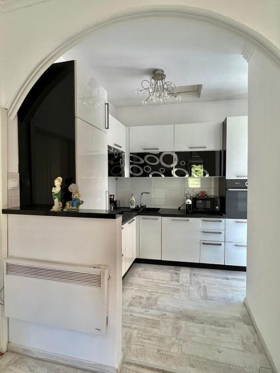 a kitchen with white cabinets and a chandelier at Apartment Kiki in Kotor
