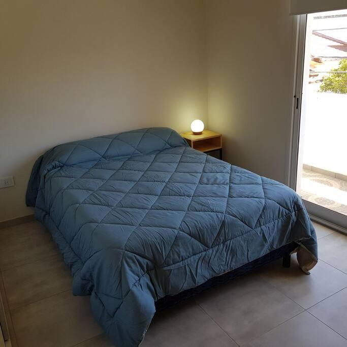 ein blaues Bett in einem Schlafzimmer mit einem Fenster in der Unterkunft Dpto. San Luis Zona Shopping/centro in San Luis