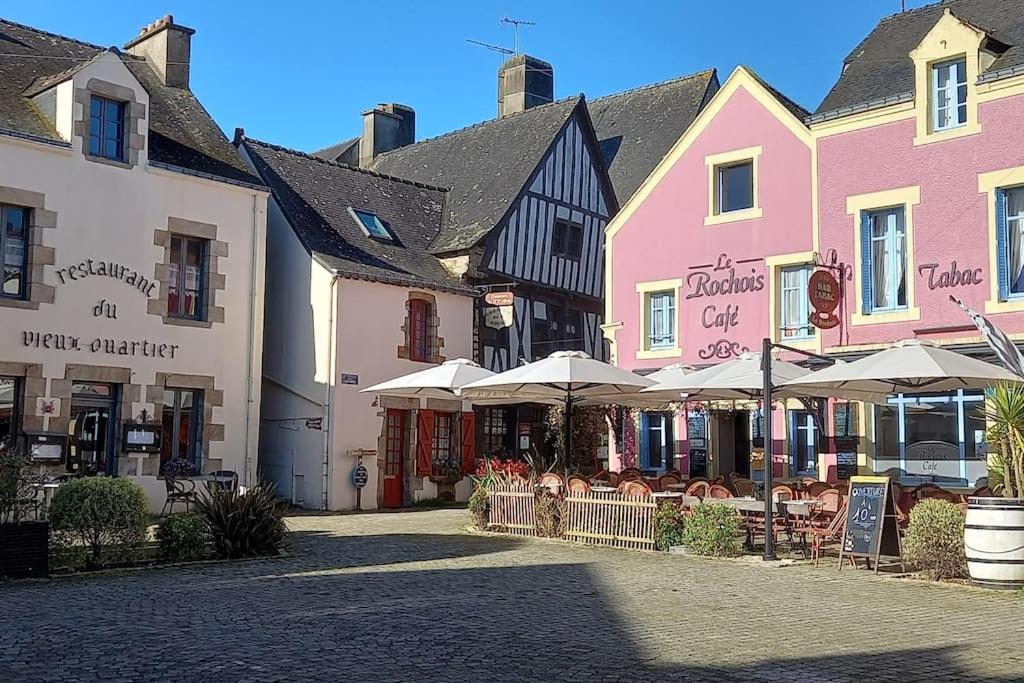 a group of buildings with tables and umbrellas on a street at chez Amédée, location en bord de Vilaine in Marzan