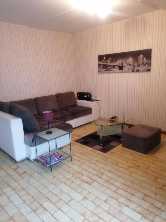 ein Wohnzimmer mit einem Sofa und einem Tisch in der Unterkunft Gaillarde in Brive-la-Gaillarde