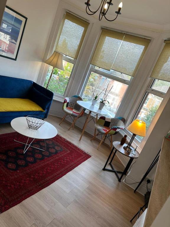 a living room with a blue couch and a table at double bedroom close to common park & city centre in Southampton