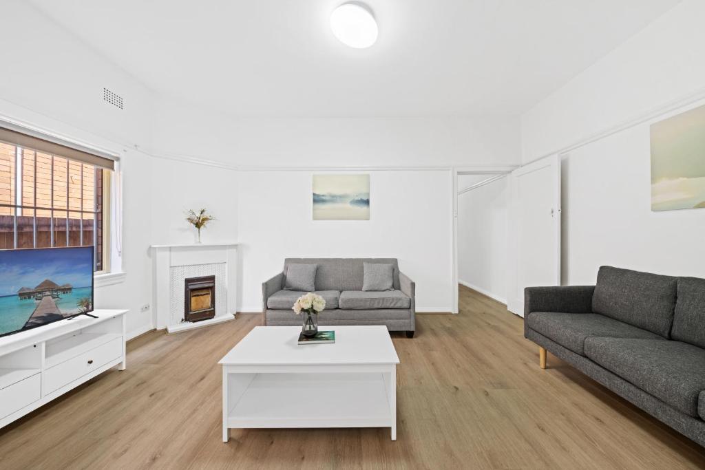 un soggiorno con divano e TV di Burwood City Newly renovated 2 Bed 2 Bath Free Private Parking Big Apt a Sydney
