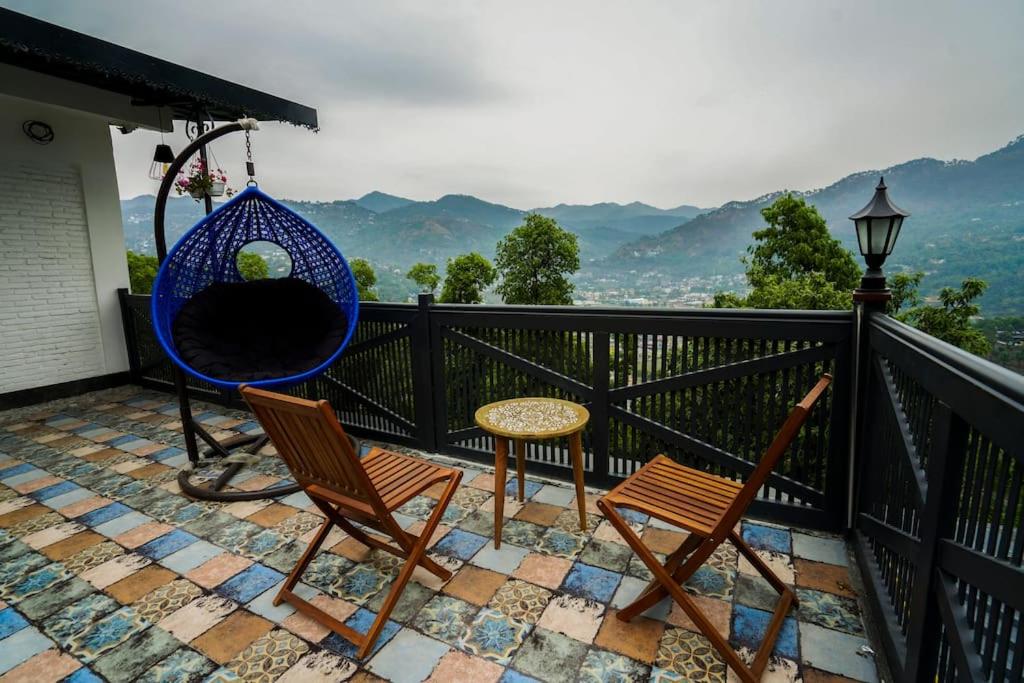 a balcony with two chairs and a swing at The Apricity Bhimtal in Bhīm Tāl