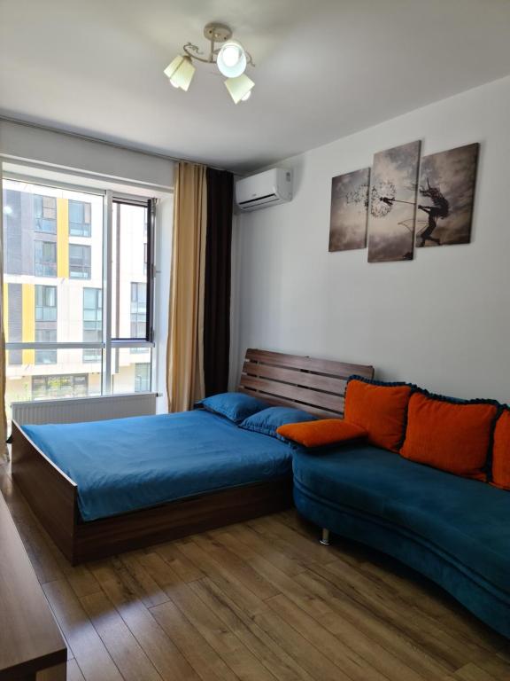 1 dormitorio con cama, sofá y ventana en Abay 130 en Almaty