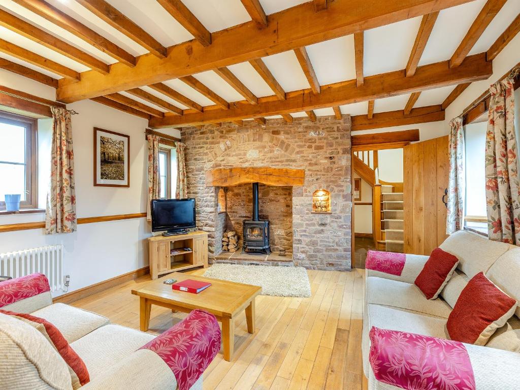 a living room with two couches and a stone fireplace at The Lodge in Lydney