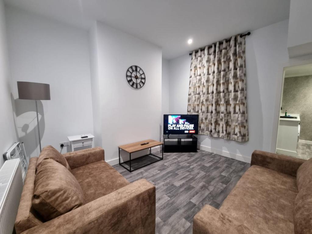 sala de estar con sofá y TV en Manchester St by Prestige Properties SA en Barrow in Furness