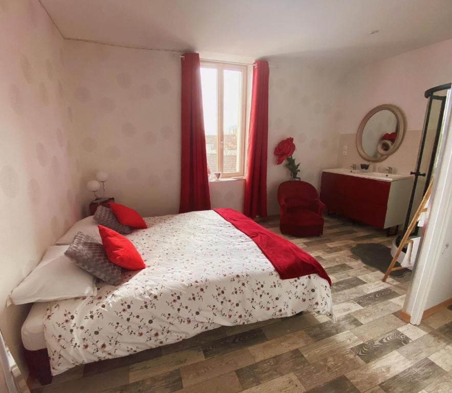 a bedroom with a bed with red curtains and a mirror at Chambres d’hôte au Chapeau Claque Cabaret in Gueugnon