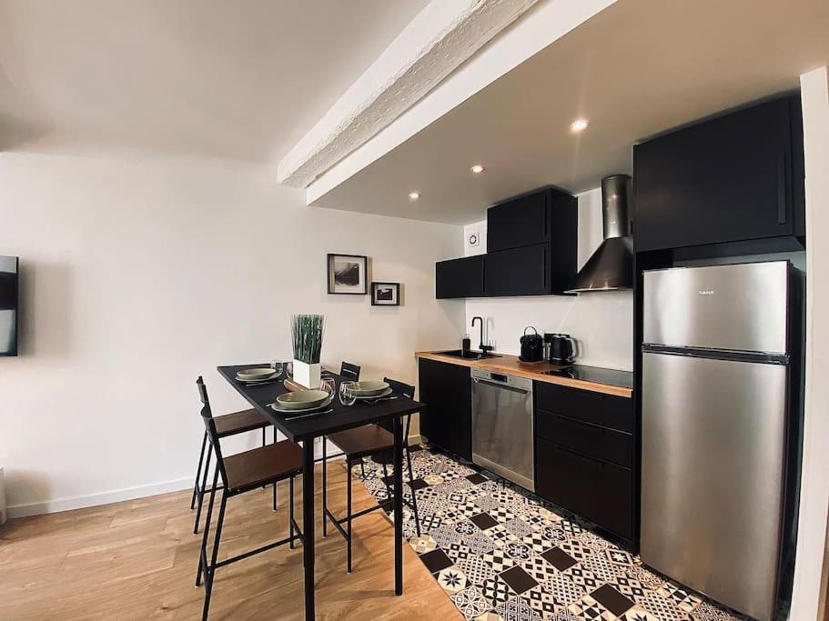 kuchnia ze stołem i lodówką ze stali nierdzewnej w obiekcie Appartement Centre ville, Cannes le Suquet w Cannes