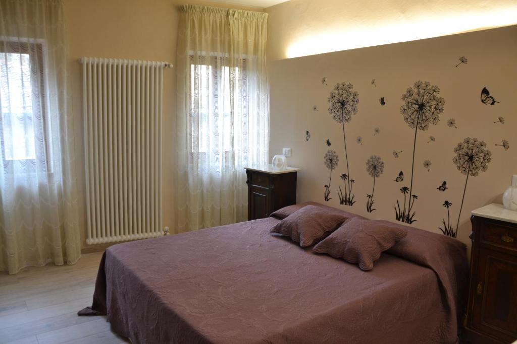 a bedroom with a bed with flowers on the wall at Il nido dei Priori in Volterra