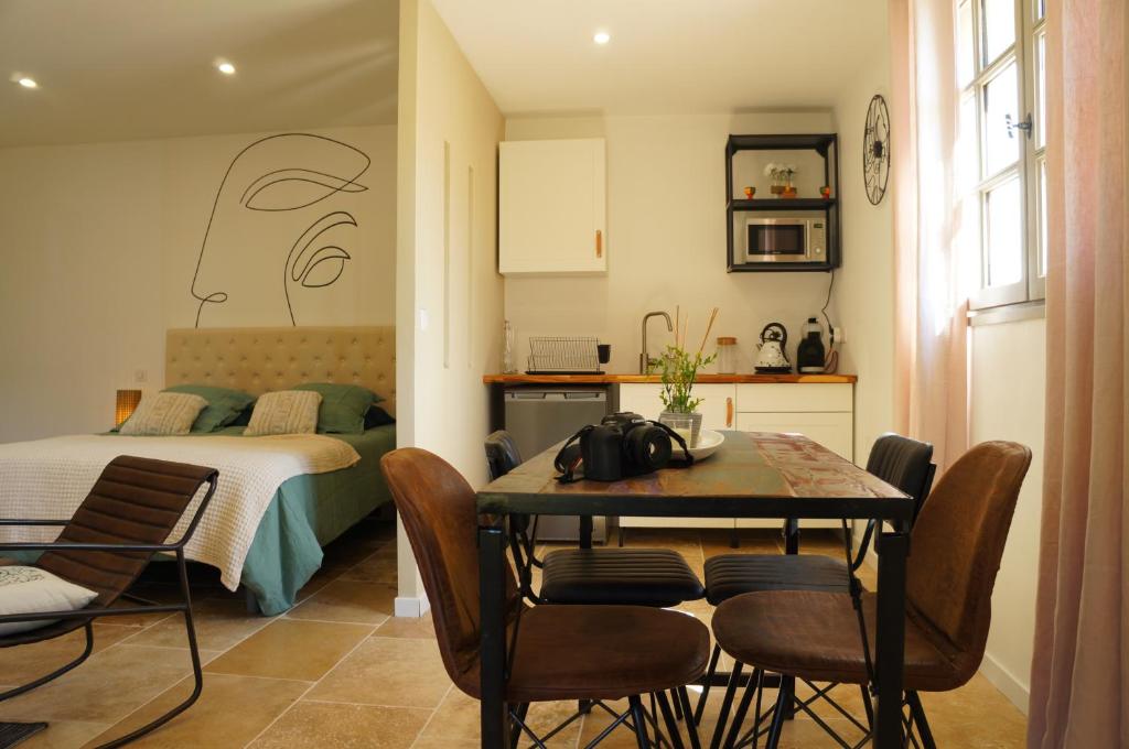 une pièce avec une table, des chaises et un lit dans l'établissement La Suite du Mas Lauseta - clim et park, à Aigues-Mortes