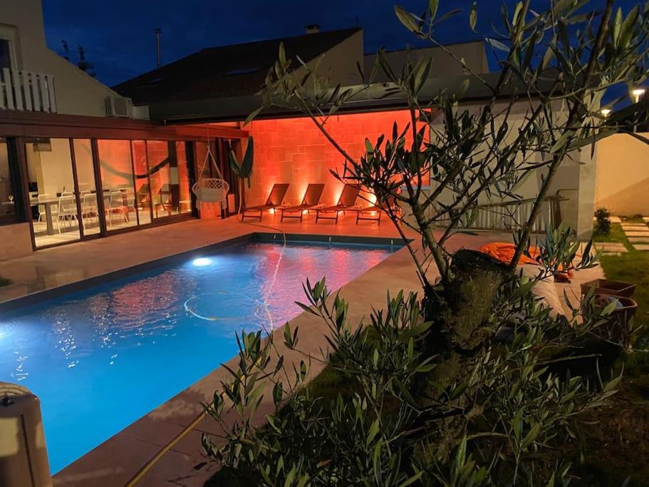 una piscina frente a una casa por la noche en Maison spacieuse, quartier calme, piscine chauffe, en Cenon