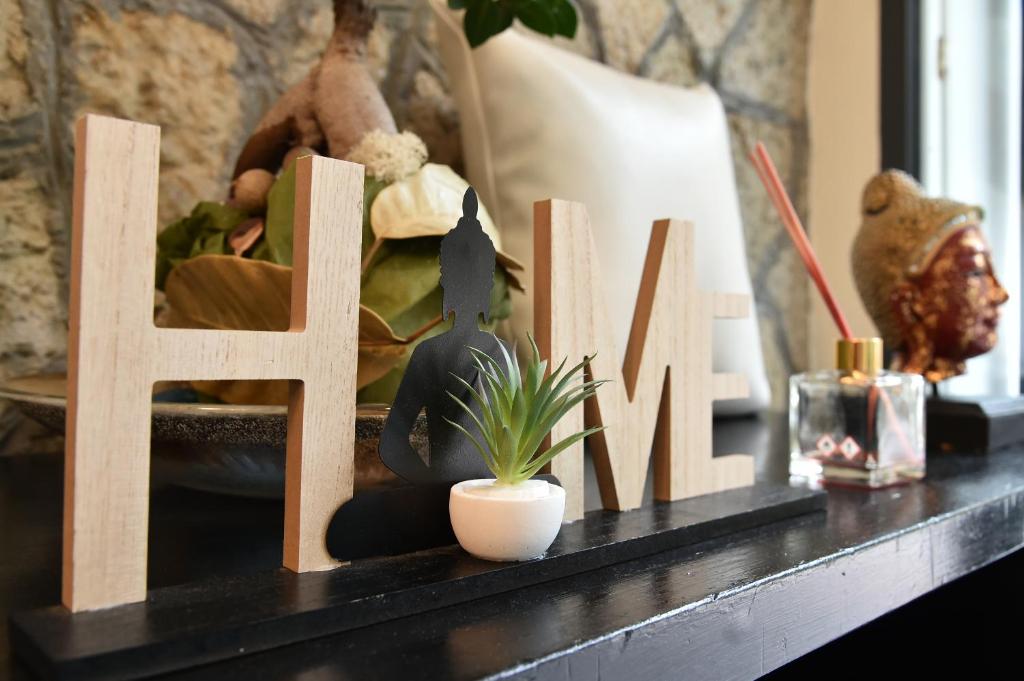 リミニにあるホテル オキナワの木の看板と植物の黒いテーブル