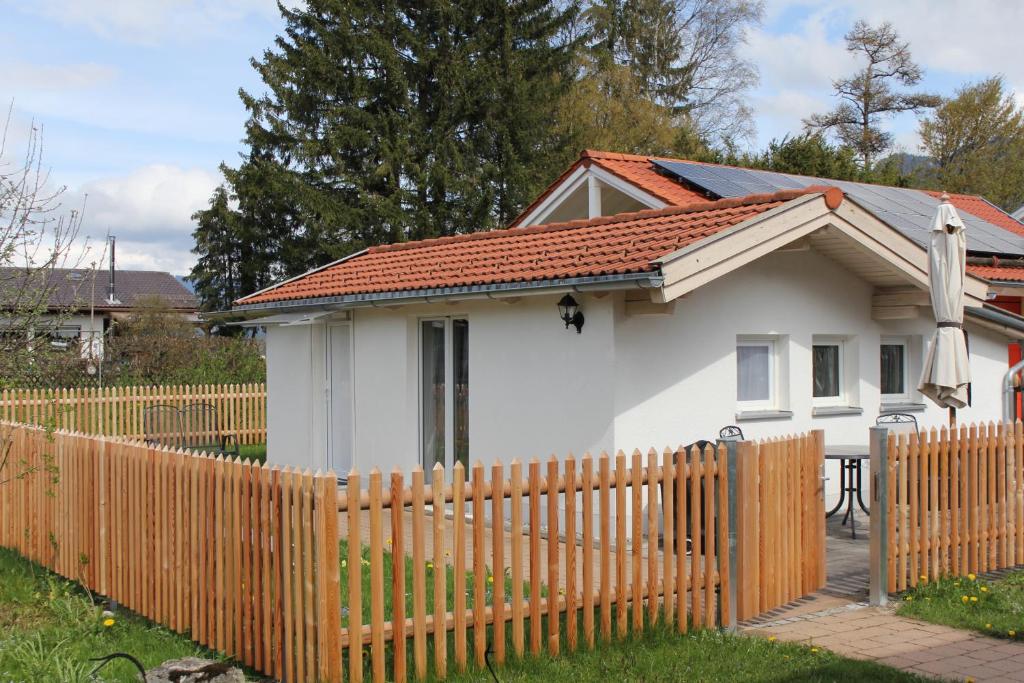 een klein wit huis met een houten hek bij Ferienhaus Franzl in Schwangau