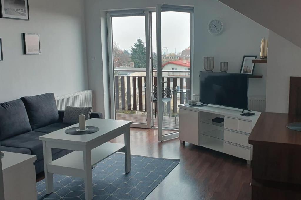 ブワディスワボボにあるMieszkanie Słoneczne Reja 2Bのソファとテーブルとテレビのあるリビングルーム