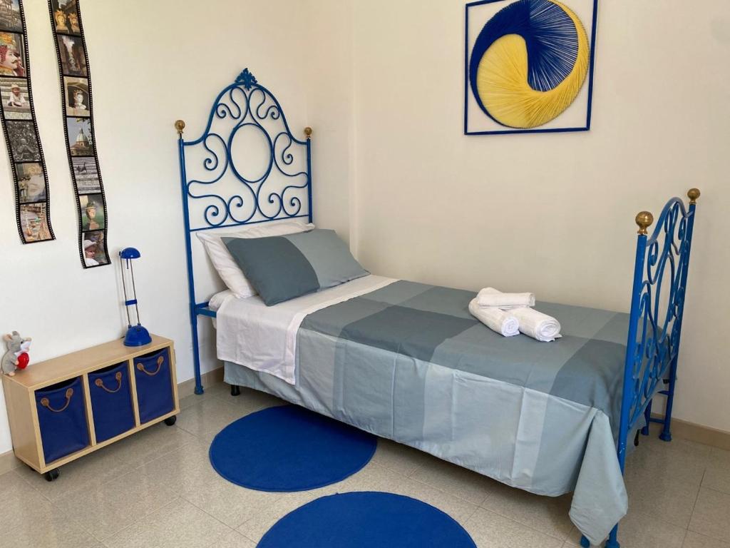 a bedroom with a blue bed and a night stand at Vista Azzurra in Marina di Modica