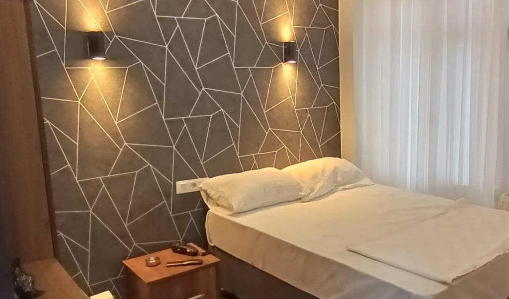 Cama pequeña en habitación con pared en Ay Butik Otel, en Elazığ
