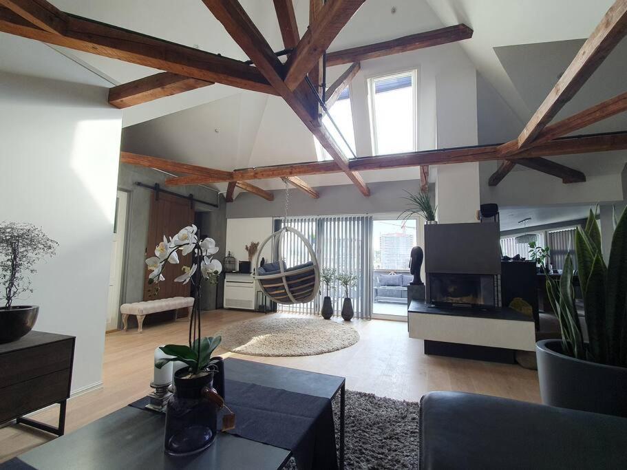 un soggiorno con soffitti in legno e un tavolo di Modern loftsleilighet a Fredrikstad