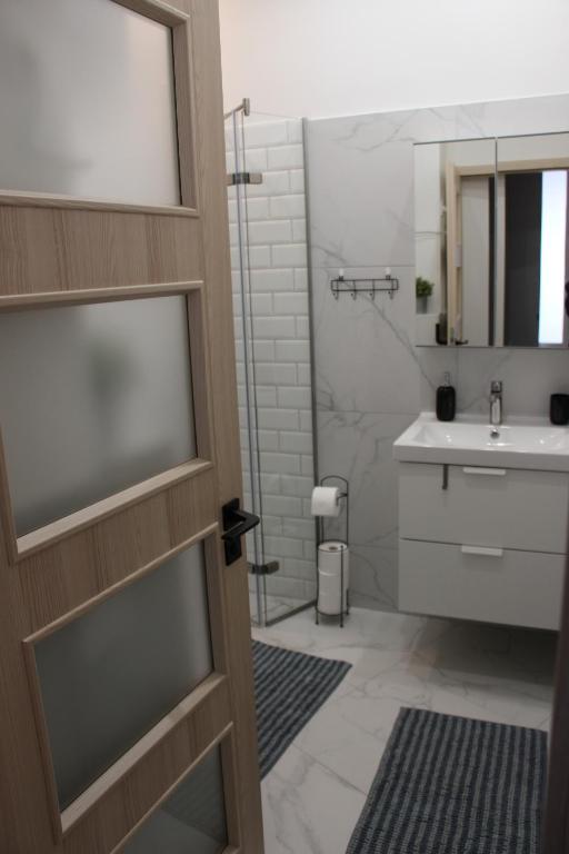 y baño con ducha y lavamanos. en Larix apartman, en Budapest