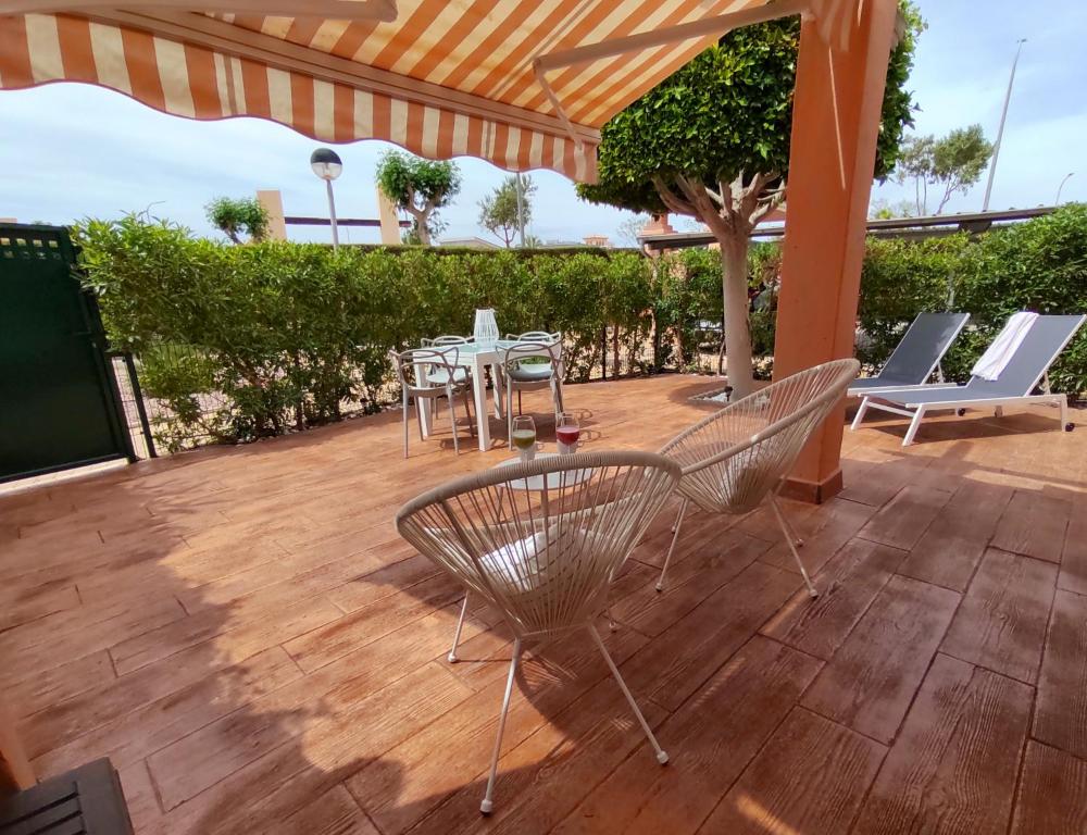 a patio with chairs and a table on a deck at VERALID Gran terraza, Wi Fi y AC en Puerto Rey in Vera