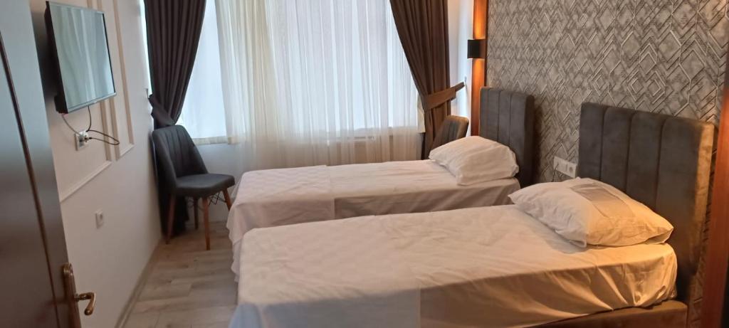 a hotel room with two beds and a television at Ay Butik Otel in Elazığ