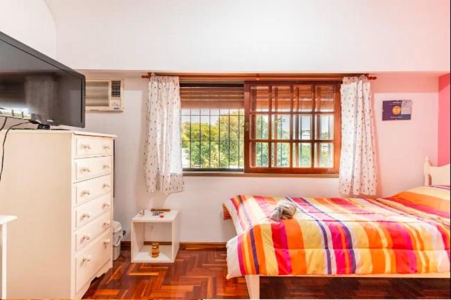 1 dormitorio con 1 cama, vestidor y ventana en Experiencia Olivos en Florida