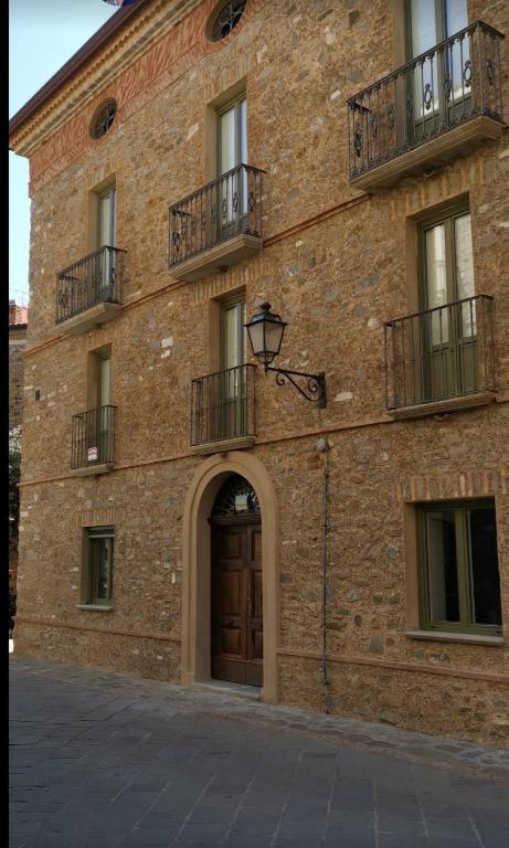 a brick building with a door and a balcony at Domus plano de laczarulo Acciaroli in Acciaroli
