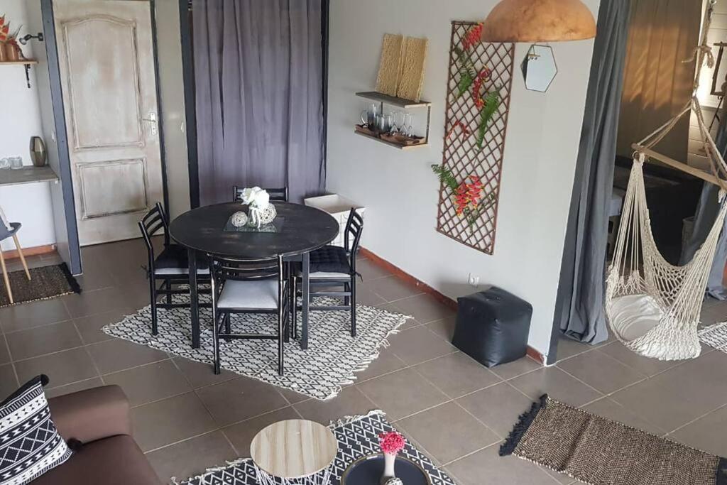 a dining room with a table and chairs and a room at L'Eucalyptus in La Trinité