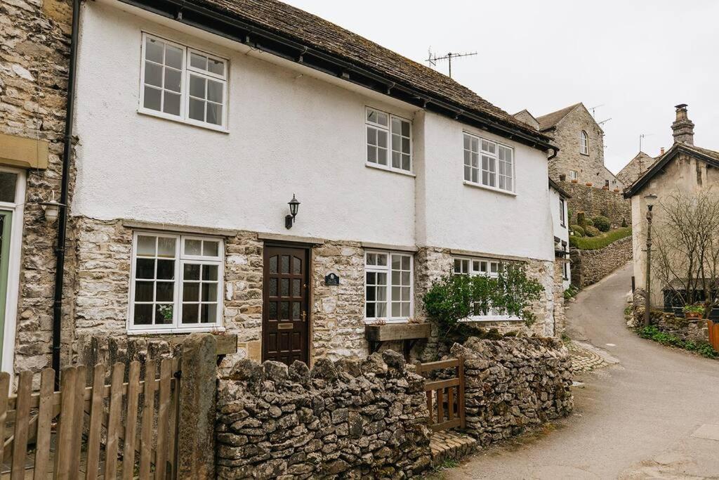 an old stone house with a stone wall at CLIFFE COTTAGE - Countryside Cottage in Castleton, Peak District National Park in Castleton