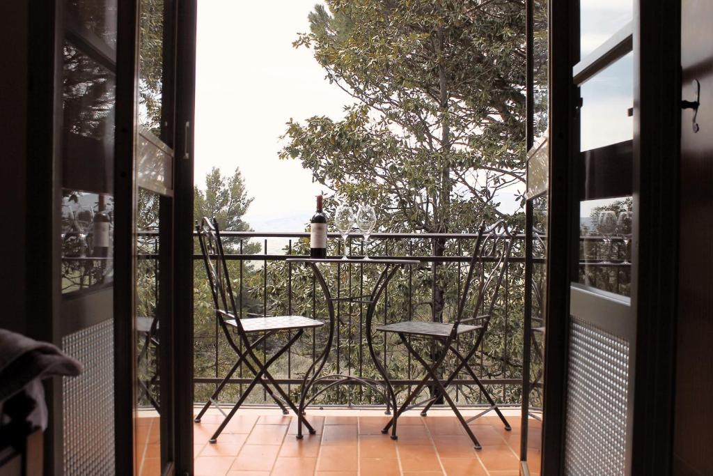 un balcón con 2 sillas y una botella de vino en il nuvoloso, en Città della Pieve