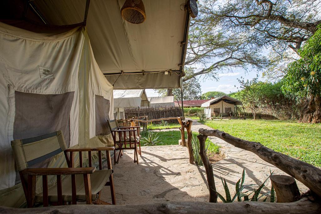 ein Zelt mit Stühlen und Tischen auf einem Feld in der Unterkunft Kara-Tunga Safari Camp in Moroto