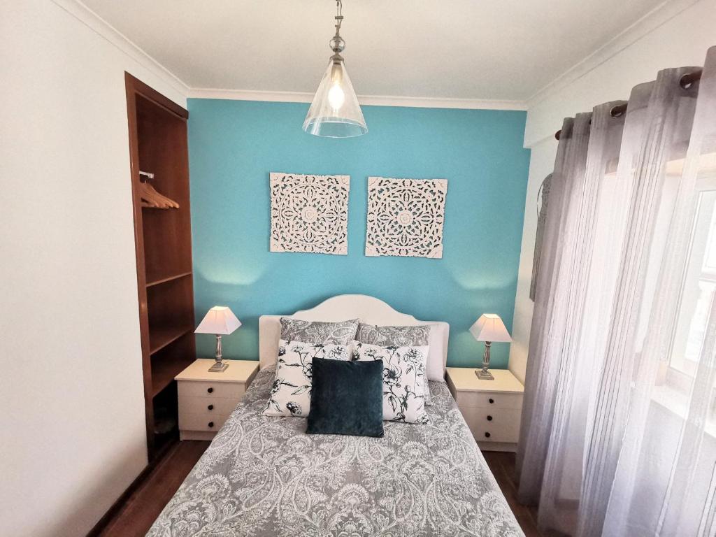 ナザレにあるApartamento Solymarのベッドルーム1室(枕付きのベッド1台、青い壁付)