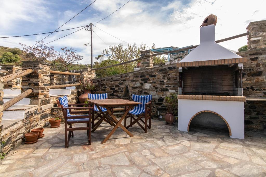 a patio with a table and chairs and a fireplace at Family holiday home 'Arokaria' in Skaládhos