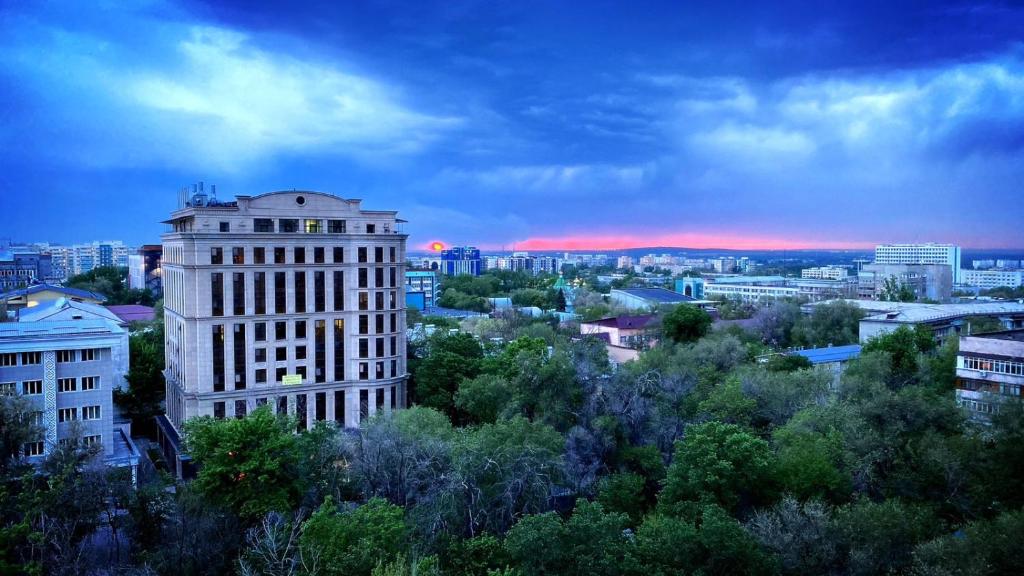 uitzicht op een stad met gebouwen en bomen bij Xata 1+2 in Alma-Ata