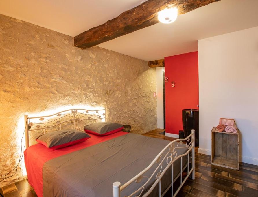ein Schlafzimmer mit einem Bett in einem Zimmer mit roten Wänden in der Unterkunft Domaine de Laplan in Cézan
