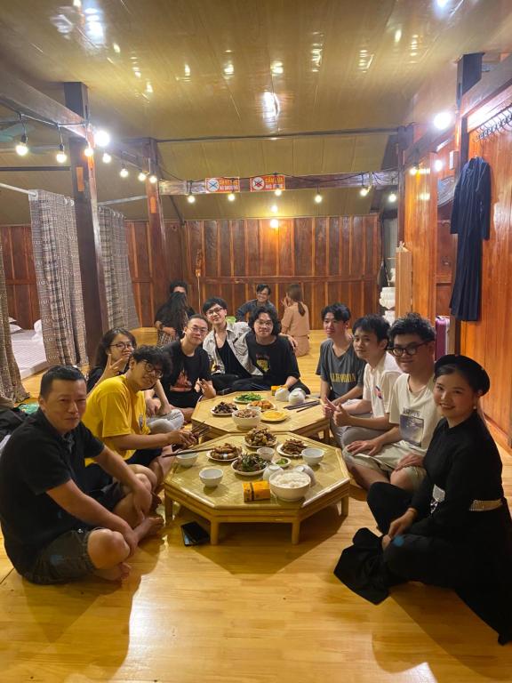 a group of people sitting around a table at Tuệ Nhi Homestay Ngườm Ngao Bản Giốc in Cao Bằng