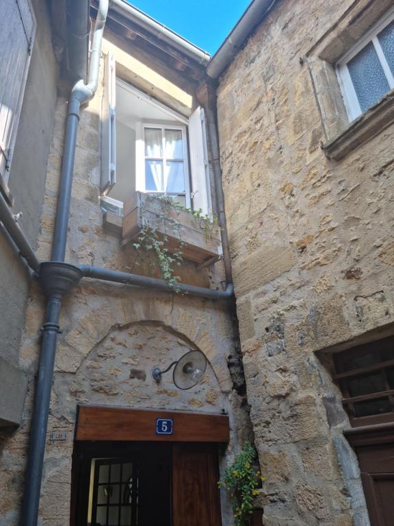 un edificio de piedra con puerta y ventana en Maisonnette au Cœur de la cité Médiévale. en Sarlat-la-Canéda